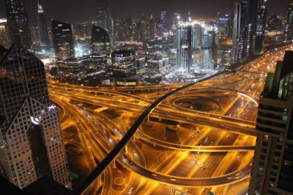 Stunning aerial view of Dubai's illuminated highways and skyscrapers at night.