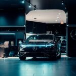Luxurious black Mercedes-Benz displayed in a futuristic showroom setting.