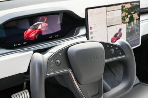 Premium Tesla dashboard featuring dual screens and innovative steering wheel design.