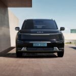 Sleek black electric SUV parked in a contemporary architectural environment.