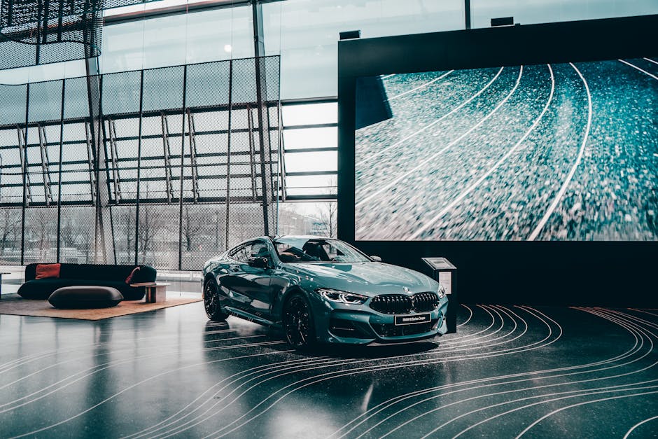 Elegant luxury coupe showcased in a modern Munich auto showroom with glass architecture.