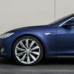 Navy blue electric vehicle showcasing sleek design and front wheel close-up.