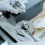 Technician inspecting and testing an opened electric vehicle battery pack before module replacement.