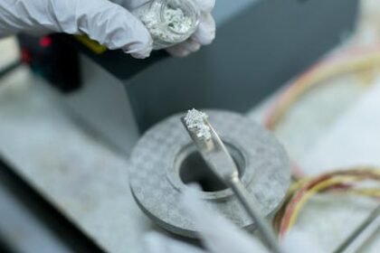 Technician inspecting and testing an opened electric vehicle battery pack before module replacement.