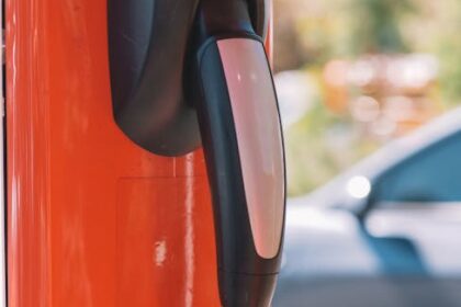 Close-up of an electric car charging station with blurred vehicle in the background.